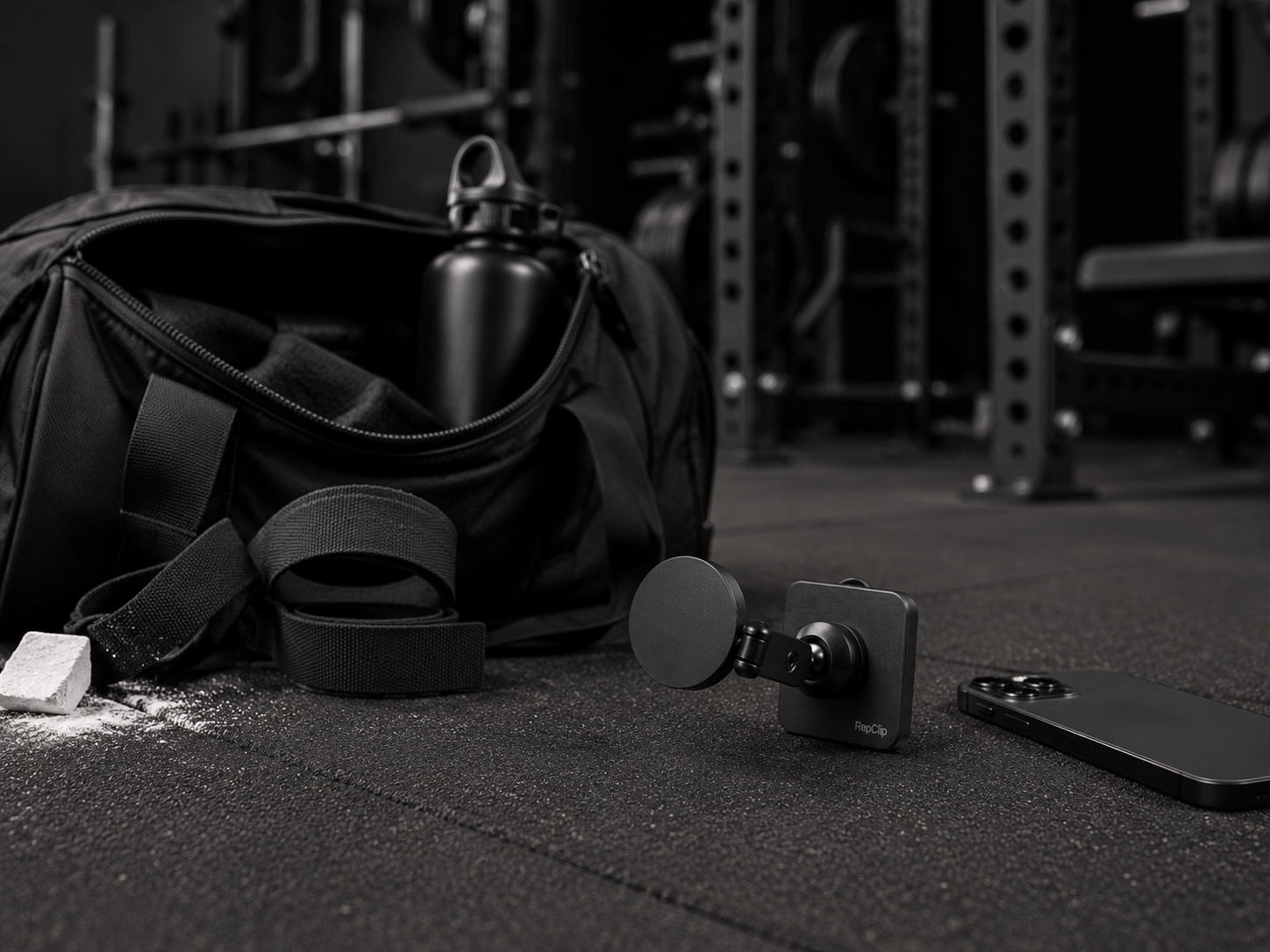 RepClip next to a phone and gym bag on the gym floor